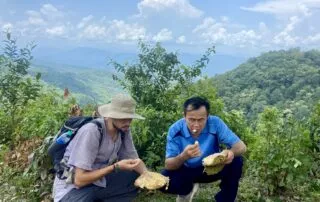 A tourist and a local Thai guide eating freshly harvested jackfruit