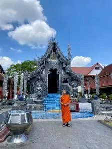 Front view of Silver Temple Chiang Mai with a Monk standing in front of the temple