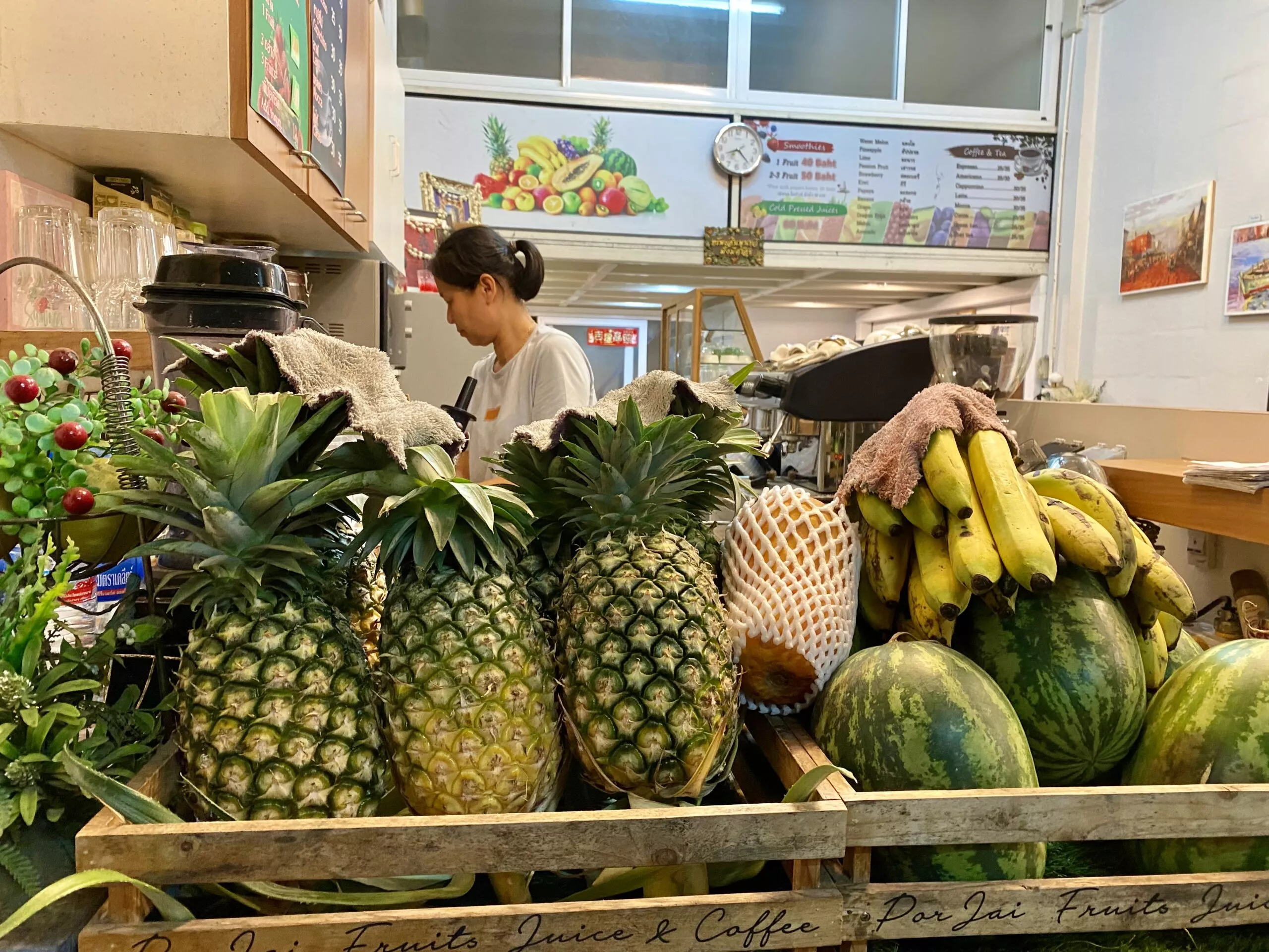 Front of a shop showing fresh fruits like pineapple, banana, watermelon.