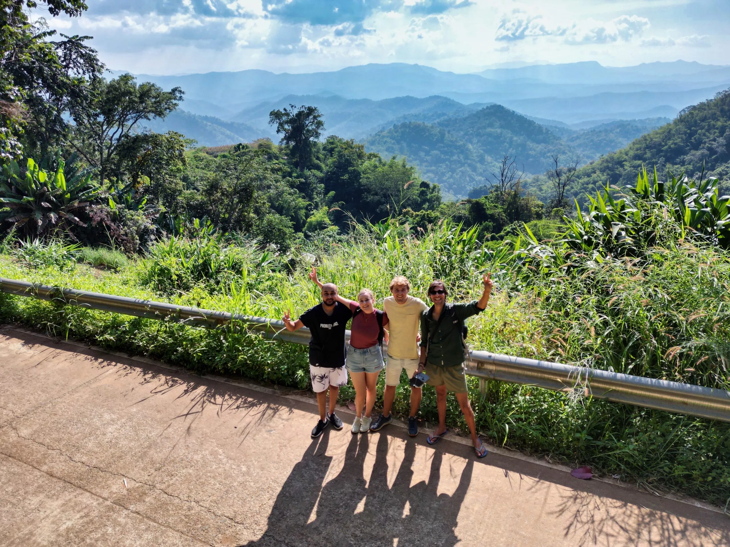 Group of friends with mountain landscape in the background, in Thailand